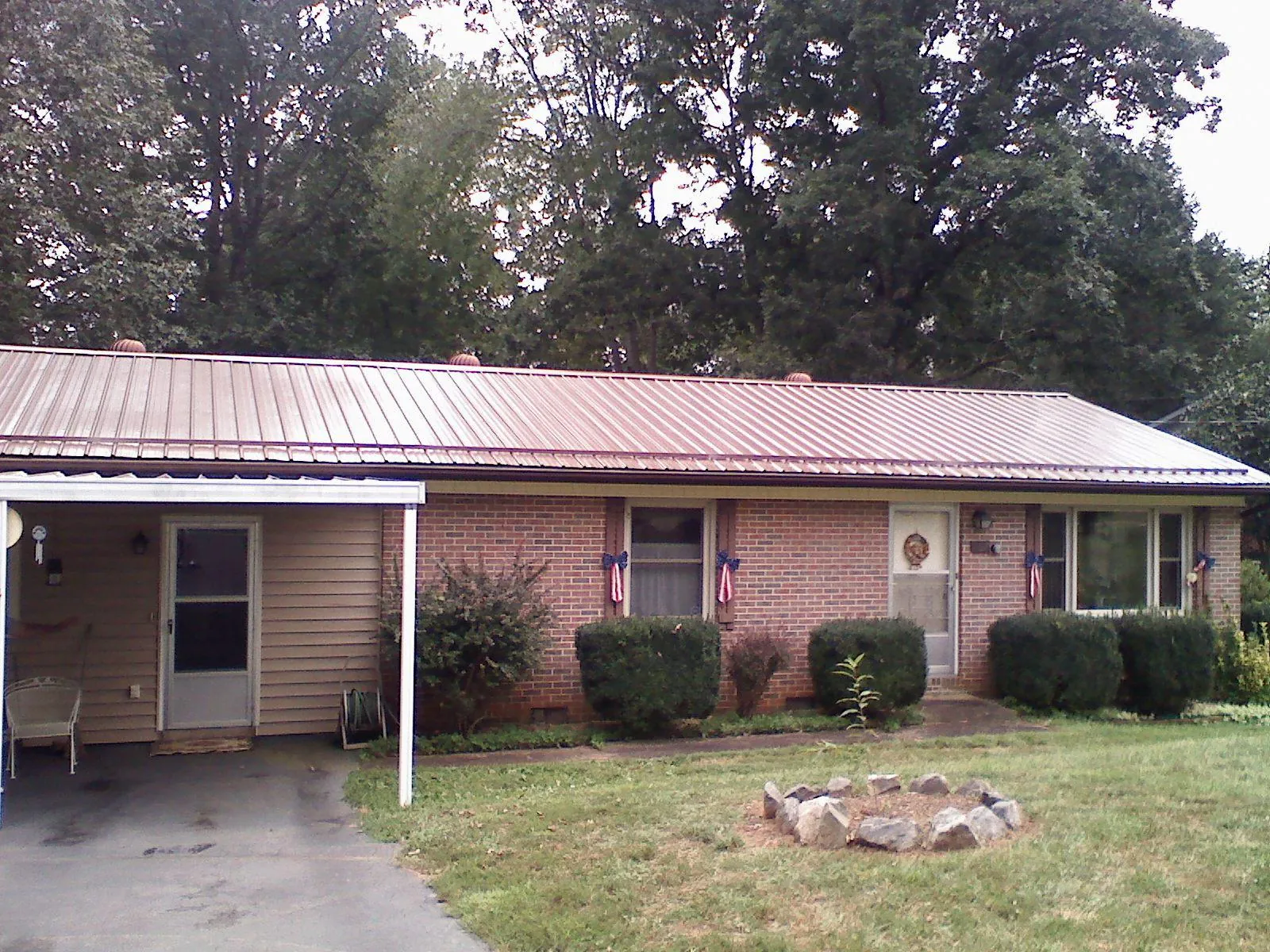 Bronze metal roof and carport on a brick ranch home — Roof Repair work by our crew in Herndon